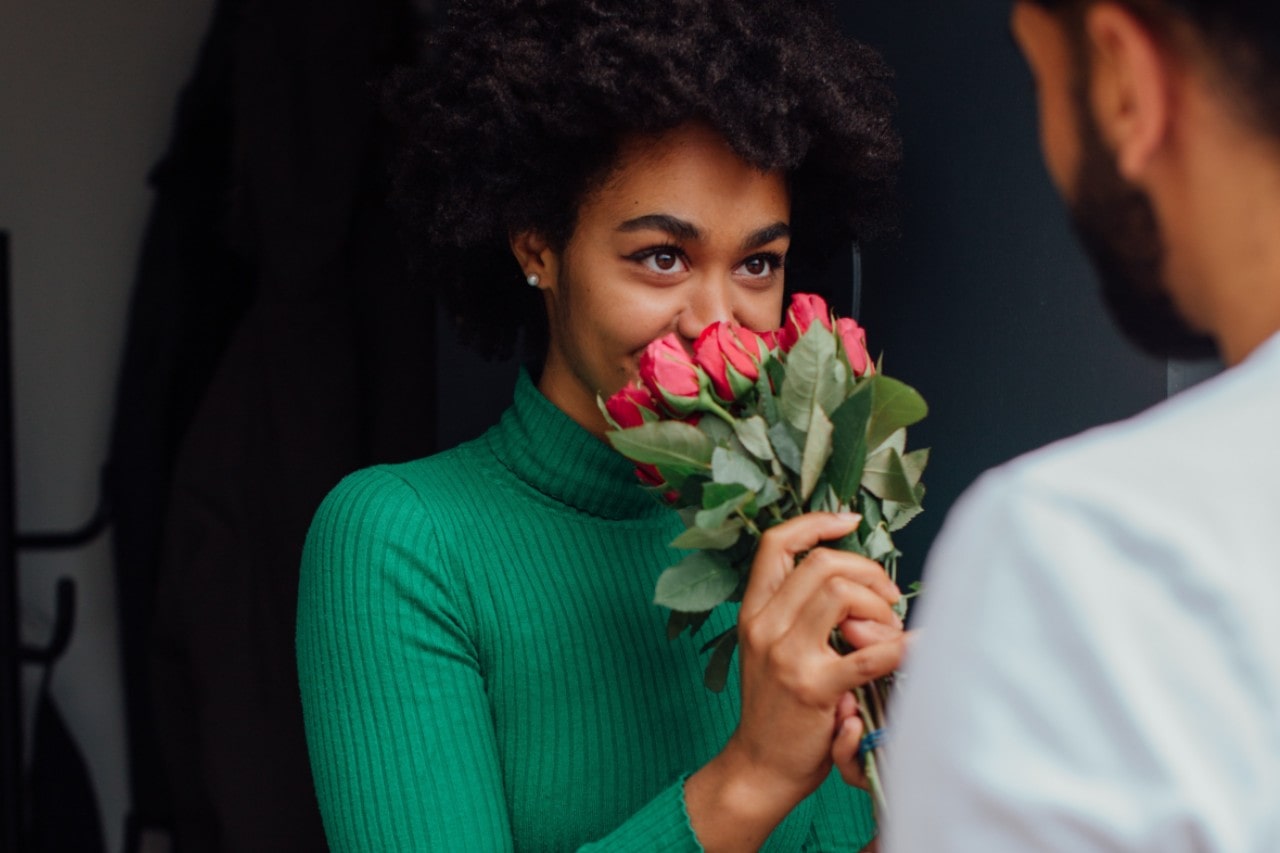a man gives his partner roses as a romantic gesture.