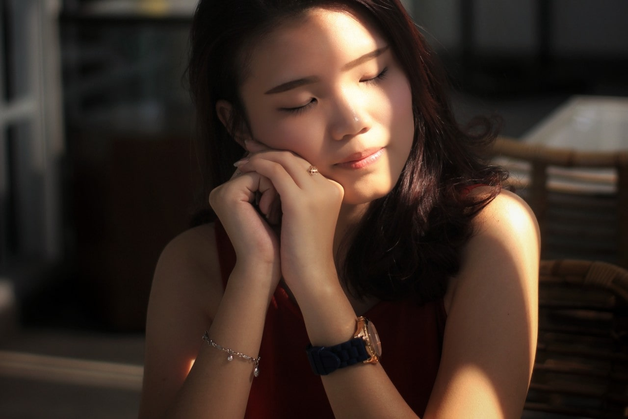 A young woman wears a gold ring to match the gold on her watch