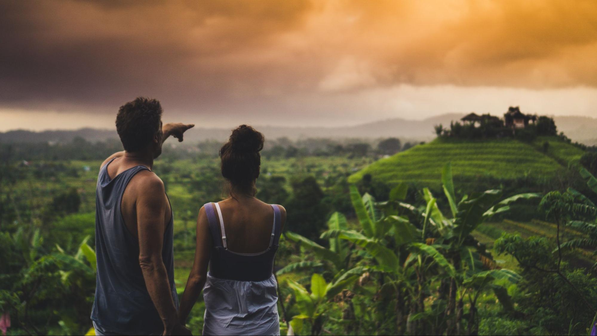 A couple looking over a large mountain with a gorgeous view of Machu Picchu at sunset.