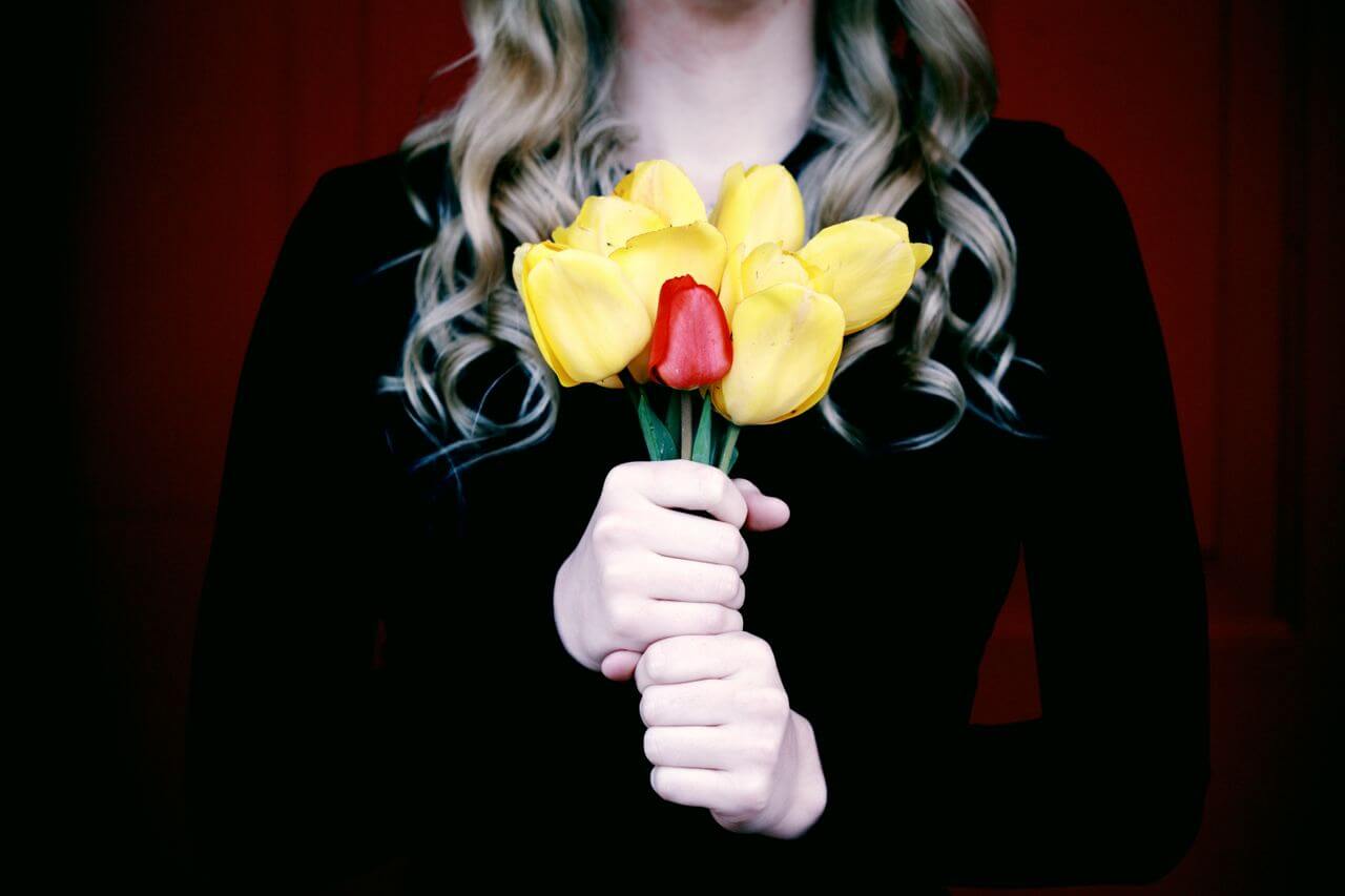 A mother holds a bundle of tulips.