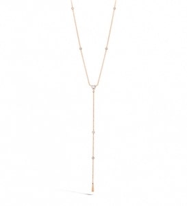 A yellow gold lariat necklace features Hearts On Fire’s signature diamond accents. 