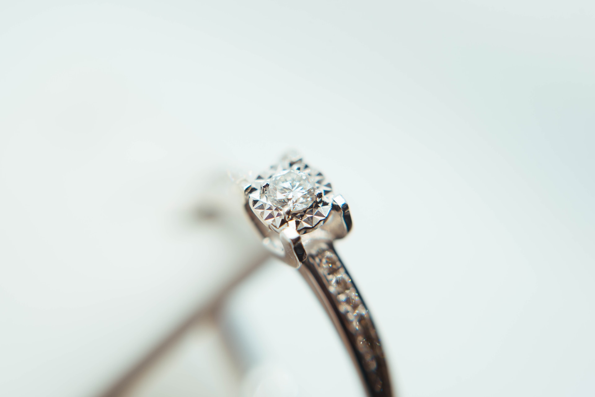 close up image of a round cut engagement ring with channel set side stones