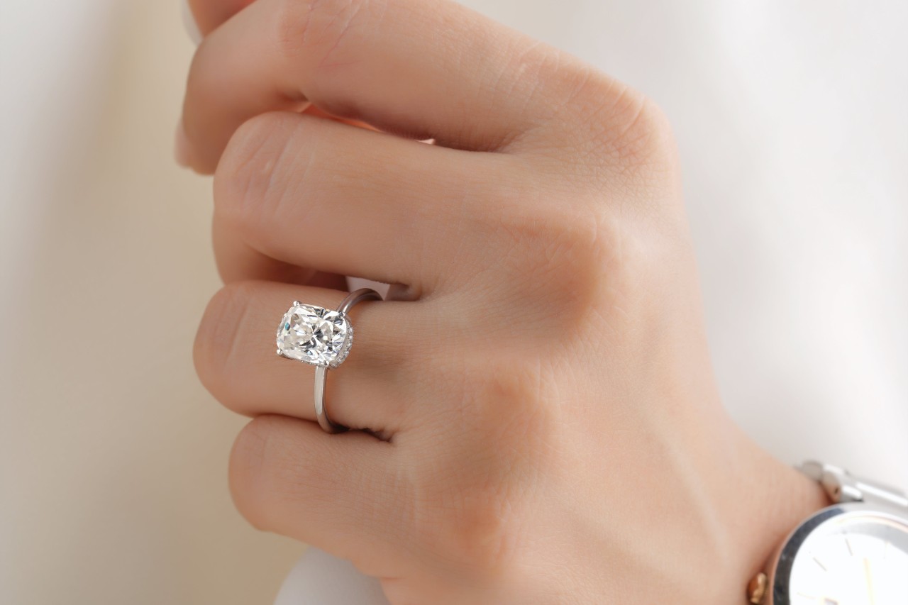 close up image of a woman’s hand wearing a silver solitaire engagement ring close up image of a woman’s hand wearing a silver solitaire engagement ring