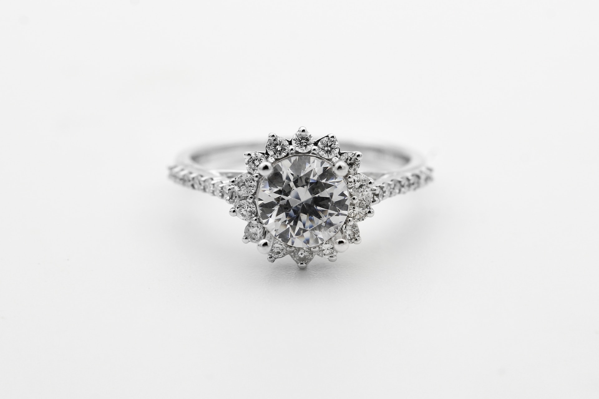 a white gold engagement ring with a floral halo and round cut center stone