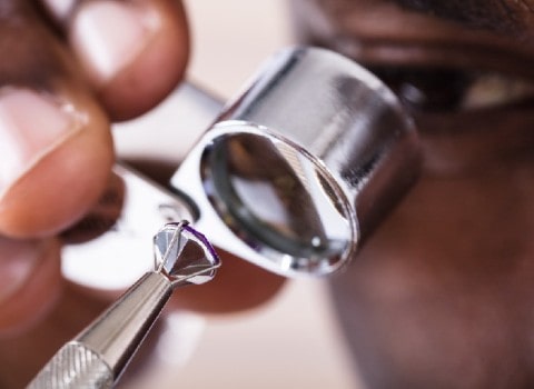 A gemologist inspects a lab-grown diamond at his work station to determine it’s authenticity.