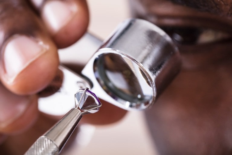 A gemologist inspects a lab-grown diamond at his work station to determine it’s authenticity.