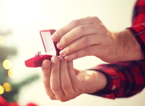 A man pops the question to his beloved with a diamond ring on Christmas Day.