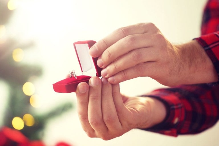 A man pops the question to his beloved with a diamond ring on Christmas Day.